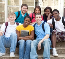 a group of smiling students sitting on steps